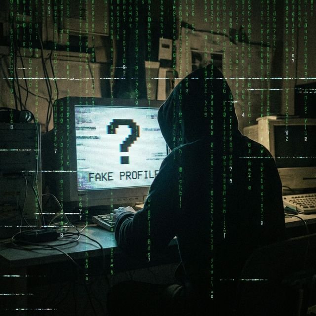 Silhouette of a person behind a computer screen with digital glitch effects